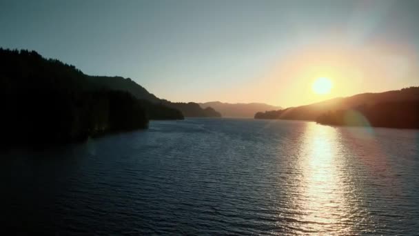 Fågelperspektiv på soluppgången över floden med kuperad terräng. — Stockvideo