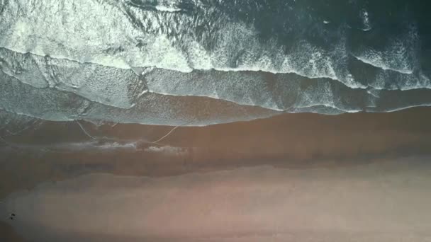 Pohled z ptačí perspektivy na oceán a písečnou pláž při západu slunce. Pláž s bílým pískem a pěnou vln oceánu. — Stock video