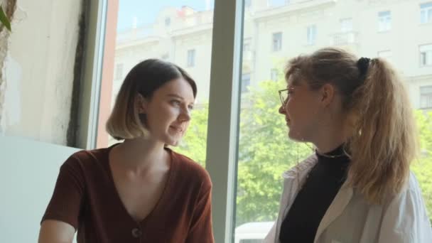 Jonge meisjes werken op afstand in een café op het zomerterras. Freelancers communiceren met collega 's via videolink. — Stockvideo