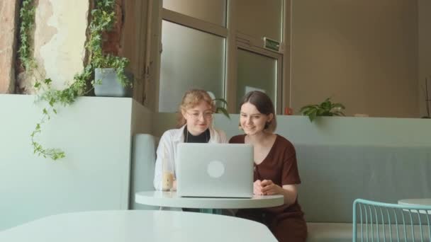 Le ragazze lavorano a distanza in un caffè sulla terrazza estiva. I freelance comunicano con colleghi via collegamento video. — Video Stock