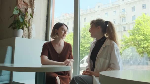 Le ragazze lavorano a distanza in un caffè sulla terrazza estiva. I freelance comunicano con colleghi via collegamento video. — Video Stock