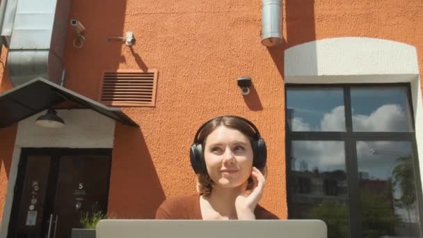 Una giovane ragazza ascolta musica in un caffè. Godersi i momenti insieme. — Video Stock