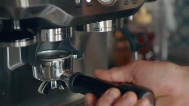 Un joven se prepara un café en casa en una máquina de café. — Vídeos de Stock