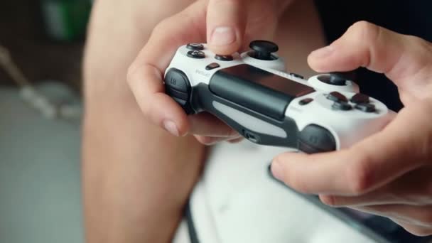 Primer plano de las manos de un joven jugando videojuegos en una consola de juegos — Vídeo de stock