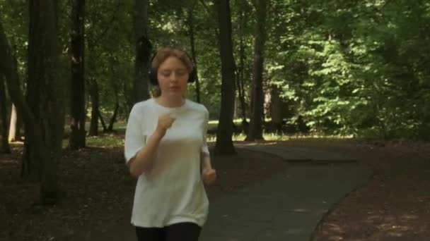En ung löpare tåg i en sommarpark, förbereder sig för att köra tävlingar. — Stockvideo