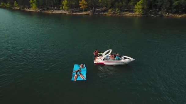 Rám sebraný z dronu. Loď se zastavila uprostřed řeky a mladí lidé skočili do vody a bavili se. — Stock video