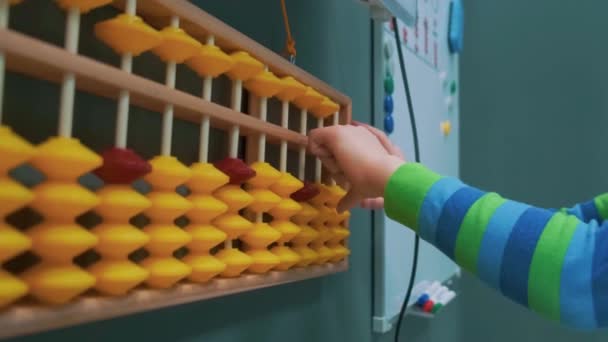 Bebê contando com abacus brincando na creche com ferramentas financeiras, ensino fundamental Close up — Vídeo de Stock