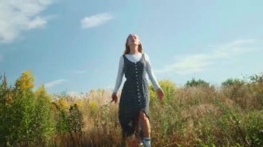Genç bir kız özgürlüğün tadını çıkarıyor. Bir kız tarlada bir buket yabani çiçekle dans ediyor..