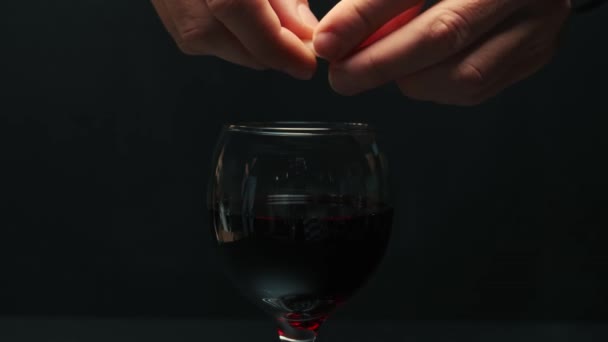 Czerwona winorośl zalana szklanym kielichem, czarne tło. — Wideo stockowe