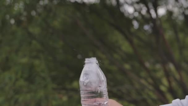 Крупный план замедленной воды, падающей из бутылки с капли брызг — стоковое видео
