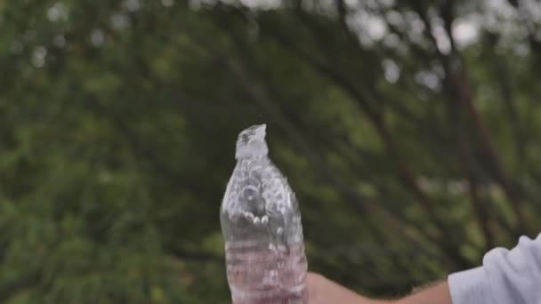 Sluiten slow motion water naar beneden vallen van de fles met druppels spatten — Stockvideo