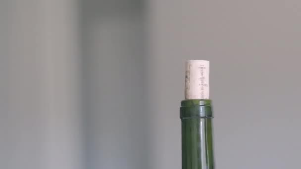Una mano abriendo una botella de vino tinto con un corcho de verdad mientras está en casa. — Vídeo de stock