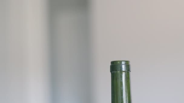 A hand closing a bottle of red wine with a real cork while at home. Close-up shot in slow motion — Stock Video