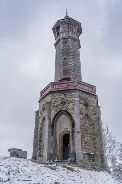 Torre de vigilancia Stepanka en la frontera de las montañas Krkonose y Jizera. Día nublado de invierno, cielo con nubes, árboles cubiertos de nieve. —  Fotos de Stock