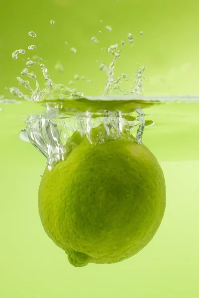 Mooi kalk in het water vallen. Groene achtergrond. — Stockfoto
