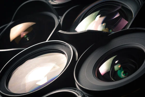 Set of DSLR lenses, different sizes and reflections. Side view. — Stock Photo, Image