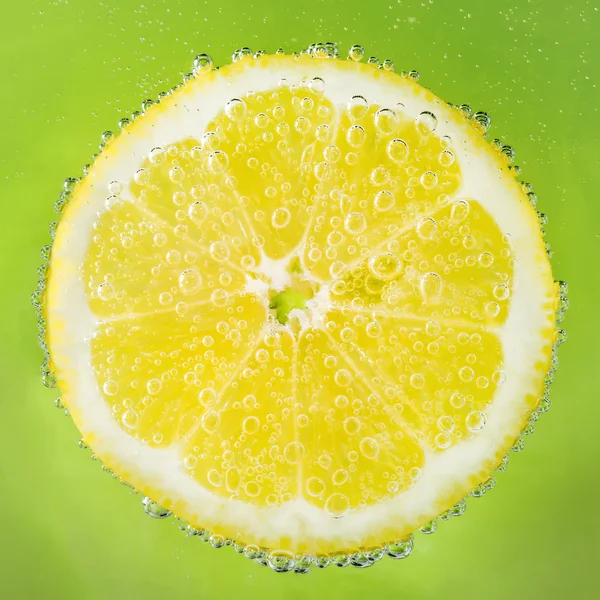 Verse citroen in natriumwater bedekt met bubbels — Stockfoto