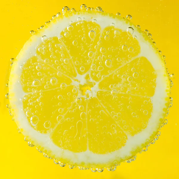 Verse citroen in natriumwater bedekt met bubbels — Stockfoto