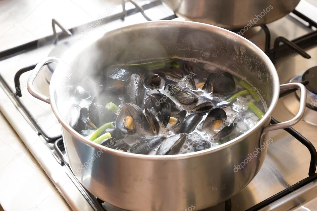 Boiling mussels in wine in a pot