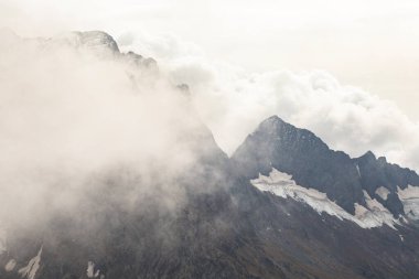 Bulutlarda kar tepeli dağ sıraları. Kafkaslar, Rusya