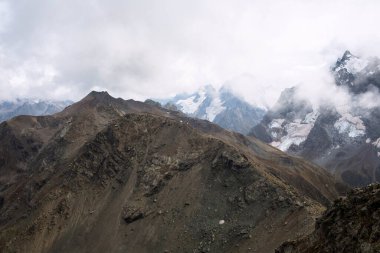 Bulutlarda kar tepeli dağ sıraları. Kafkaslar, Rusya