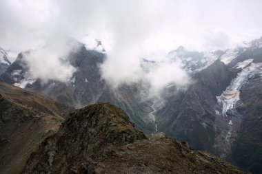 Bulutlarda kar tepeli dağ sıraları. Kafkaslar, Rusya