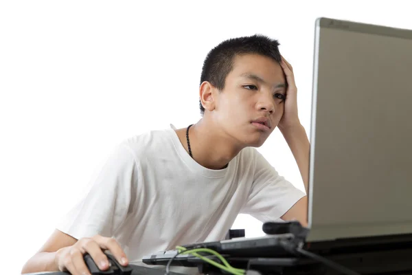 Asian teenager using computer with boring face — Stock Photo, Image
