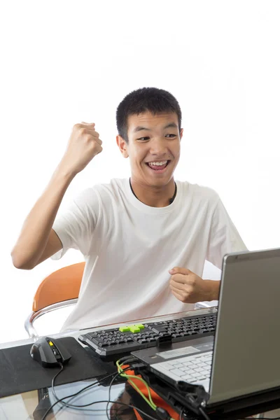 Азиатский подросток с помощью компьютера с победным жестом — стоковое фото