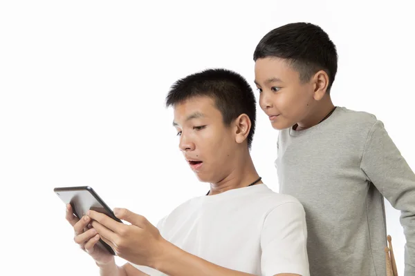 Asiático adolescente y su hermano viendo la sorpresa en su tableta — Foto de Stock