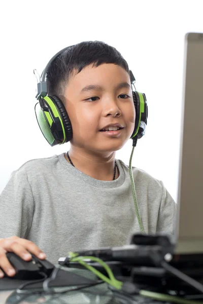 Asiatique enfant jouer à des jeux informatiques avec le sourire sur son visage Image En Vente