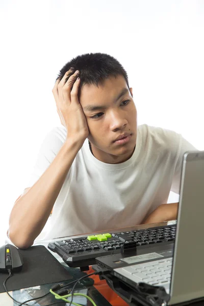 Asiatiska tonåring använder dator med tråkig ansikte — Stockfoto