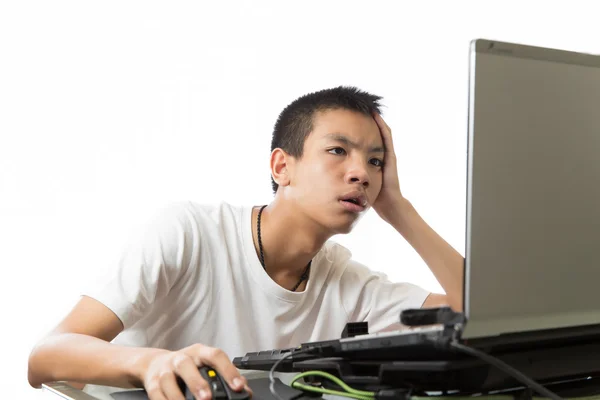 Asian teenager using computer with boring face — Stock Photo, Image