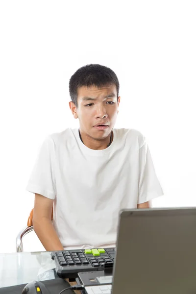 Asian teenager using computer with funny face — Stock Photo, Image