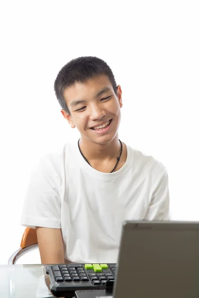 Aasialainen teini hymyilevä kasvot tietokoneen edessä — kuvapankkivalokuva