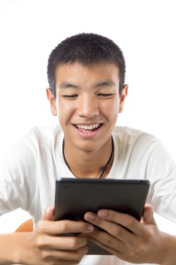 Asyalı genç tablet veya ipad gülümseme ile kullanma