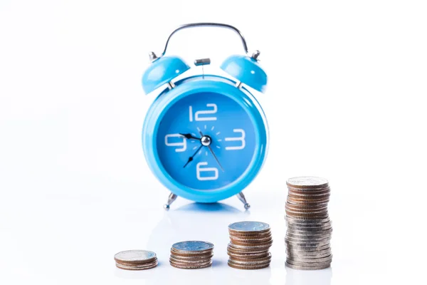 Pile of coins in graph shape with alarm clock background — Stock Photo, Image