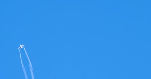 Aereo militare fa un rotolo verticale con due piste di fumo bianco nel cielo blu — Video Stock