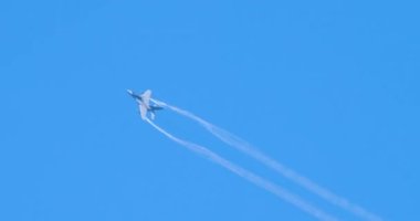 Savaş uçakları yuvarlanıyor ve mavi gökyüzünde diğer akrobatik manevralar yapıyor.