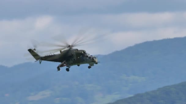 Militär helikopter i grön mimetisk kamouflage gör långsam hastighet svänger i fluga — Stockvideo