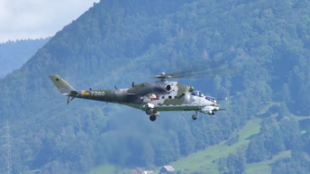 Enorme militaire helikopter in zweven in groene mimetische en bergachtige achtergrond — Stockvideo