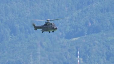 Askeri nakliye helikopteri kendi ekseni üzerinde dönerek tırmanıyor. 