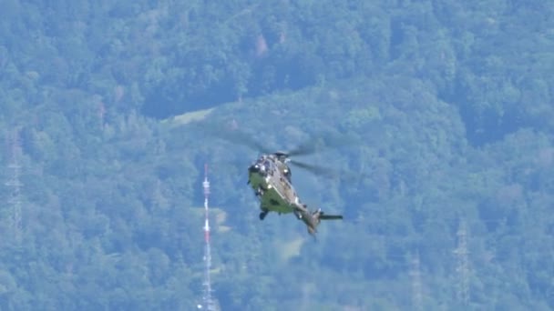 Elicottero di trasporto militare vola lentamente e si libra per atterrare in montagna — Video Stock