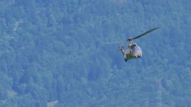 Военно-транспортный вертолет в полете между горами и крутой подъем — стоковое видео
