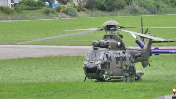 Helicóptero militar en un prado enciende el motor para despegar — Vídeo de stock