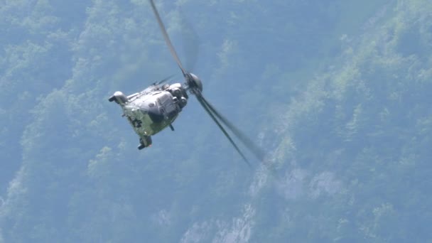 Helicóptero militar en camuflaje verde gira a máximo rendimiento en las montañas — Vídeos de Stock