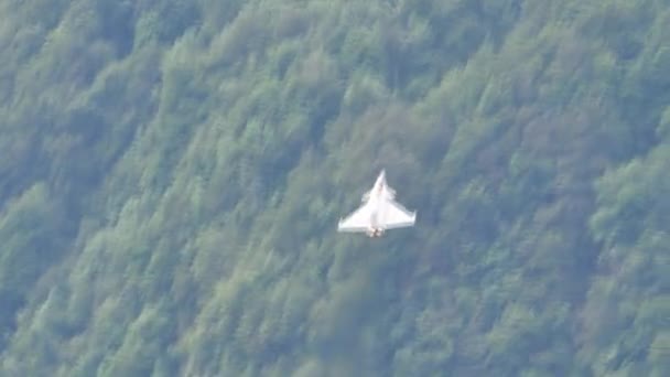 Imponujący samolot myśliwski wznosi się bardzo blisko grzbietu górskiego. — Wideo stockowe