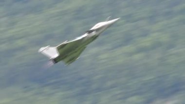 Askeri jet dağlarda yüksek hızda alçak irtifada savaş manevraları gerçekleştiriyor.