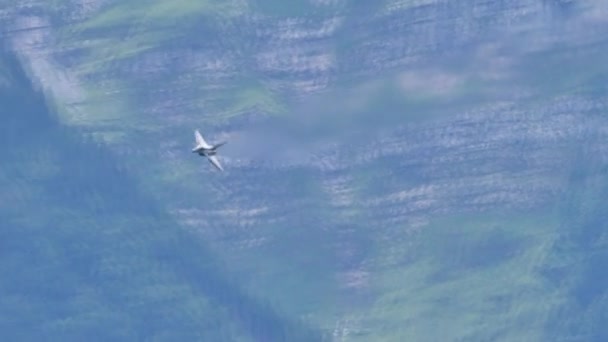 Imponerande stridsflygplan flyger med hög hastighet låg höjd i alpin dal — Stockvideo