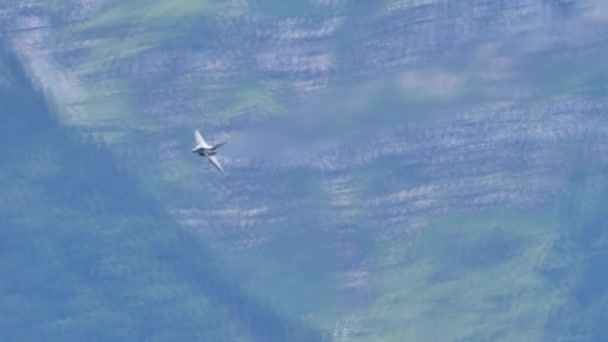 Impressionante jet da combattimento che vola ad alta velocità a bassa quota nella valle alpina — Video Stock