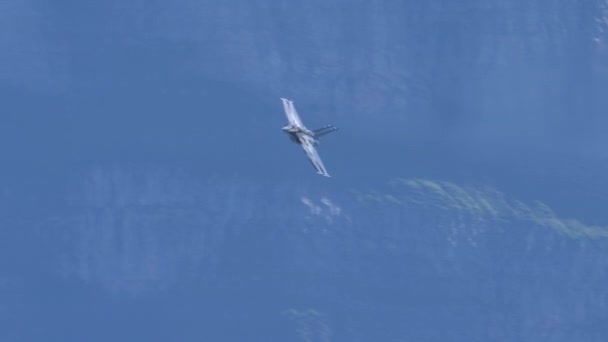 Stridande stridsflygplan som flyger i hög hastighet i en smal bergsdal — Stockvideo